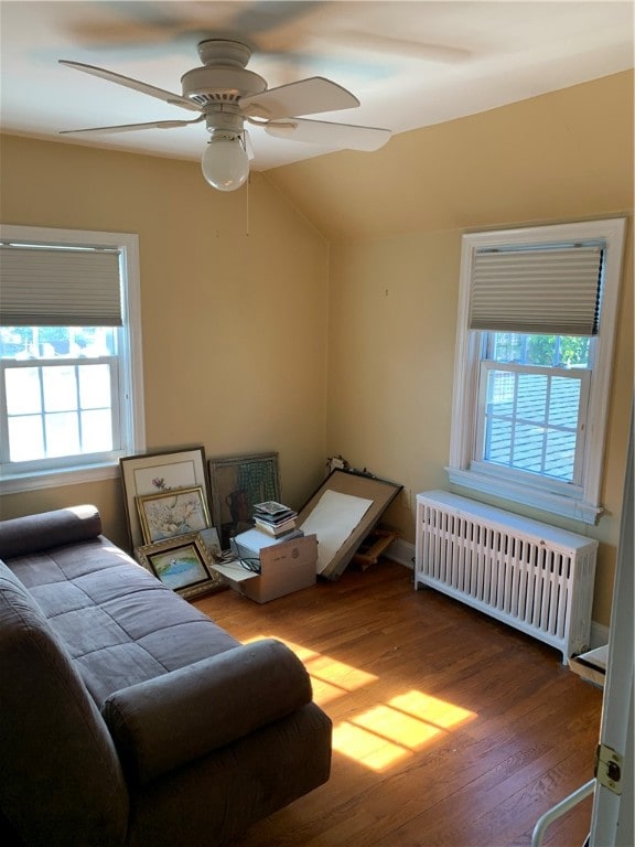 bedroom with lofted ceiling, radiator, hardwood / wood-style floors, and ceiling fan