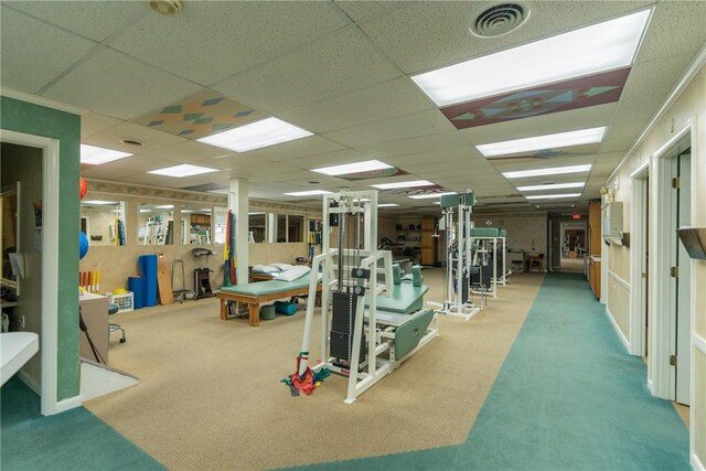 gym featuring carpet flooring and a paneled ceiling