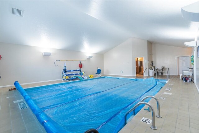 recreation room featuring vaulted ceiling and light tile patterned floors