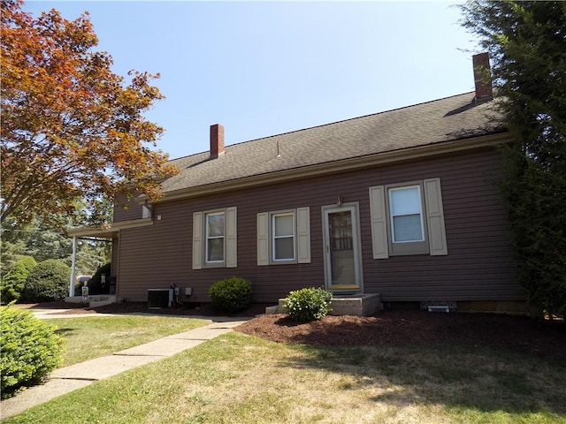 1216-1218 Clark St, White Oak, PA 15131 - view of front facade with a front yard, central air condition unit, roof with shingles, and a chimney
