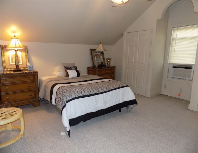 carpeted bedroom featuring lofted ceiling, a closet, and cooling unit