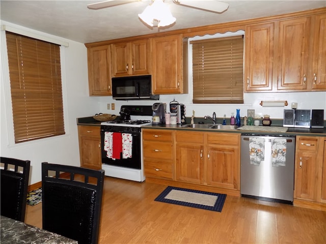 kitchen with white range with gas cooktop, light hardwood / wood-style flooring, dishwasher, sink, and ceiling fan