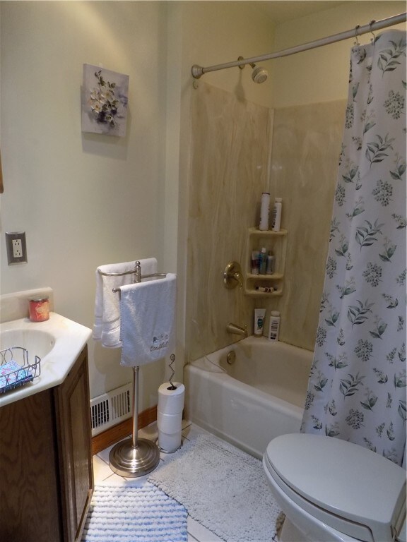 full bathroom with tile patterned flooring, toilet, shower / tub combo with curtain, and vanity