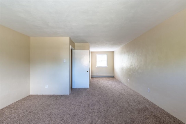 carpeted spare room featuring a baseboard heating unit