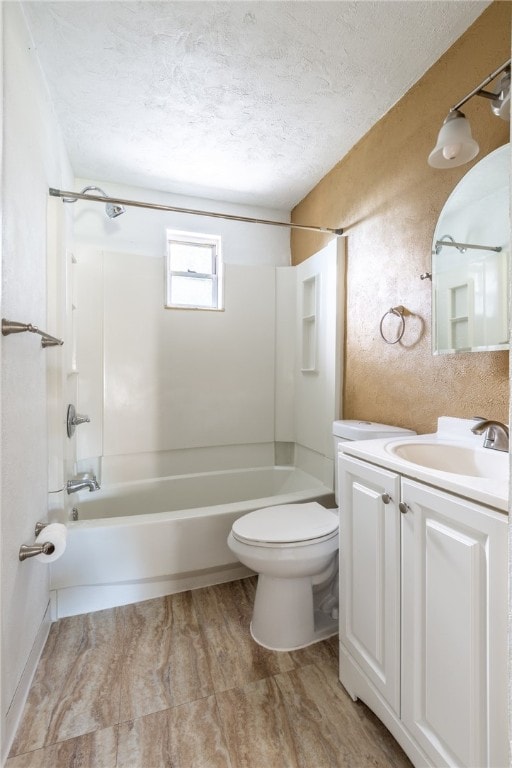 full bathroom with washtub / shower combination, toilet, a textured ceiling, and vanity