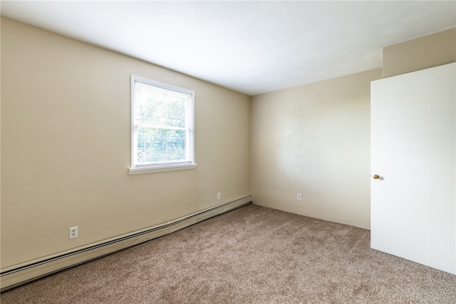 carpeted empty room with a baseboard heating unit