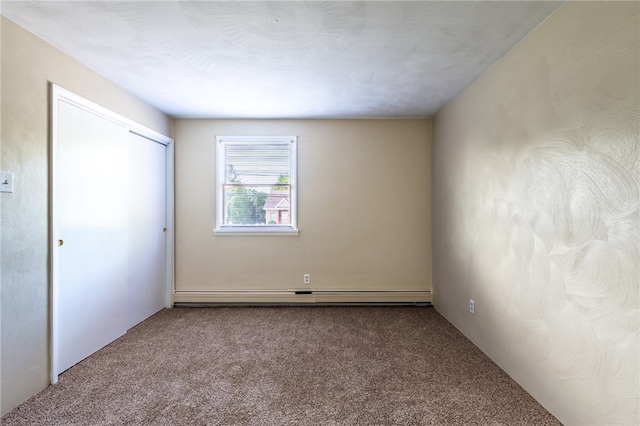 unfurnished room with a baseboard radiator and carpet