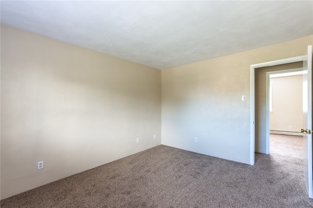 empty room featuring baseboard heating and carpet floors