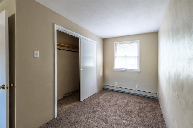 unfurnished bedroom featuring a closet, baseboard heating, and carpet