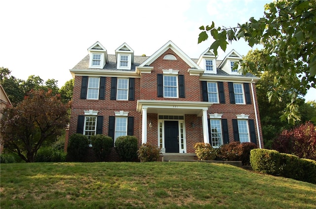 colonial inspired home featuring a front yard