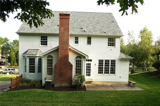 back of property with a patio and a yard