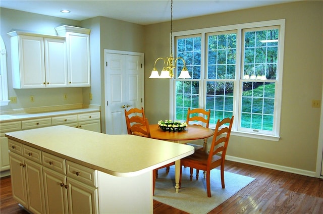 kitchen with hanging light fixtures, hardwood / wood-style floors, a center island, and plenty of natural light