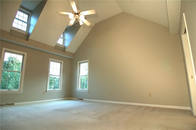 empty room featuring ceiling fan, light colored carpet, and high vaulted ceiling