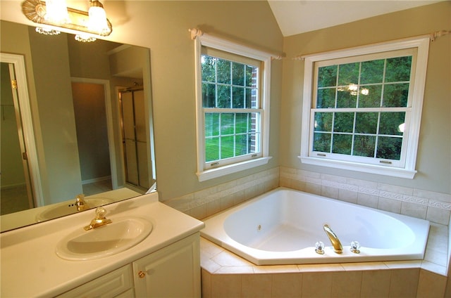 bathroom featuring shower with separate bathtub, vanity, and vaulted ceiling