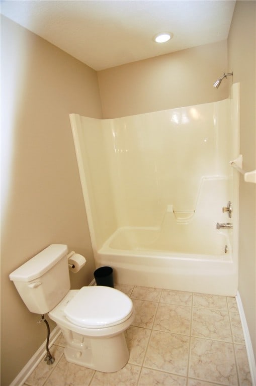 bathroom featuring bathing tub / shower combination, toilet, and tile patterned flooring