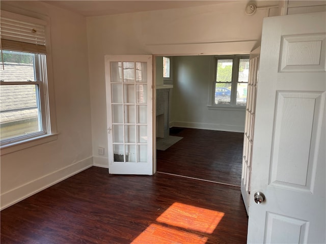 unfurnished room featuring a wealth of natural light and dark hardwood / wood-style floors