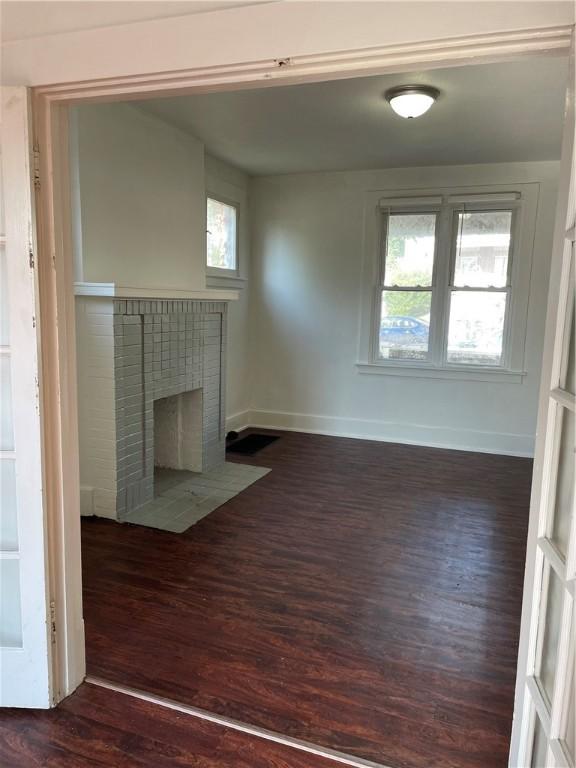 623 Beaver St, Ambridge, PA 15003 - unfurnished living room with dark wood finished floors, baseboards, and a brick fireplace