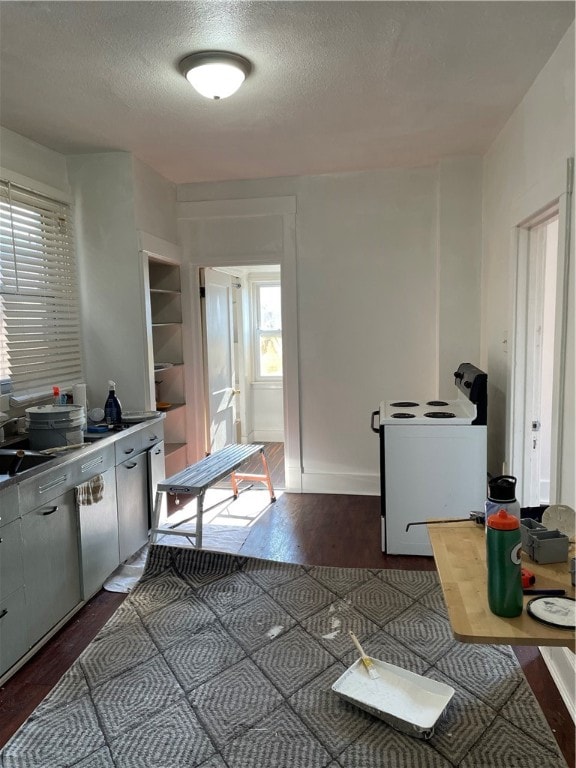 kitchen featuring a textured ceiling, dark wood-type flooring, and built in shelves