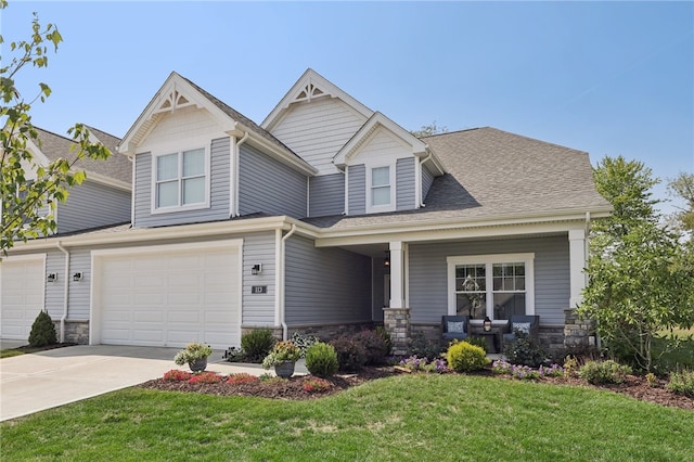 craftsman inspired home with a garage, covered porch, and a front lawn