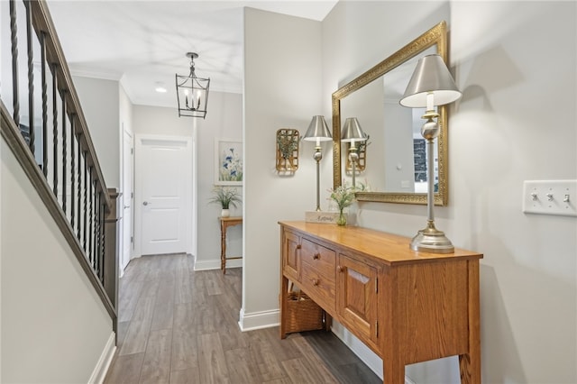 foyer entrance featuring dark hardwood / wood-style floors, an inviting chandelier, and ornamental molding