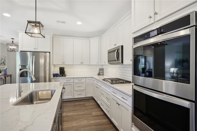 kitchen featuring decorative light fixtures, appliances with stainless steel finishes, sink, dark hardwood / wood-style floors, and decorative backsplash