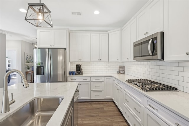 kitchen with backsplash, stainless steel appliances, dark hardwood / wood-style flooring, sink, and white cabinets