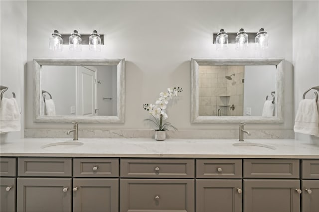 bathroom with a tile shower and vanity