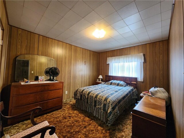 bedroom with wood walls and carpet flooring