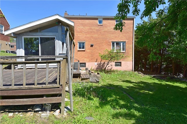 rear view of house featuring a deck and a lawn