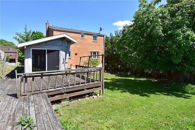 rear view of house with a deck and a lawn