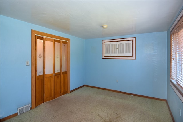 unfurnished bedroom with carpet, multiple windows, and a closet