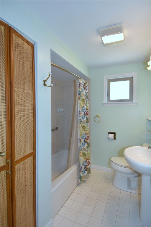 bathroom featuring tile patterned flooring, toilet, and shower / tub combo