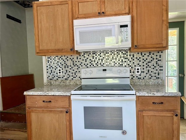 kitchen with white appliances, light stone counters, and decorative backsplash