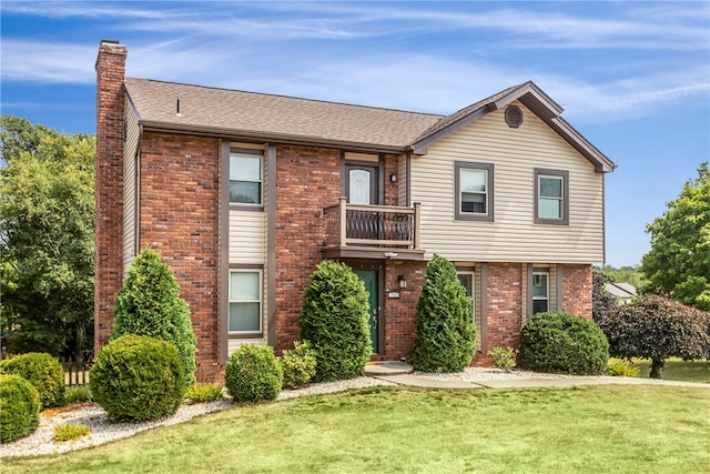 view of front of home with a balcony and a front yard