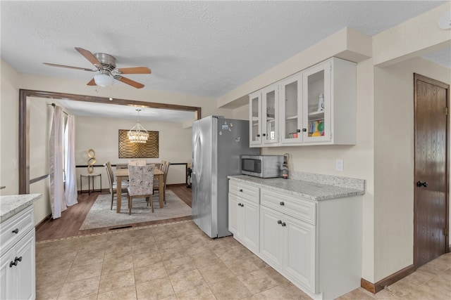 kitchen with light hardwood / wood-style flooring, light stone counters, and white cabinets