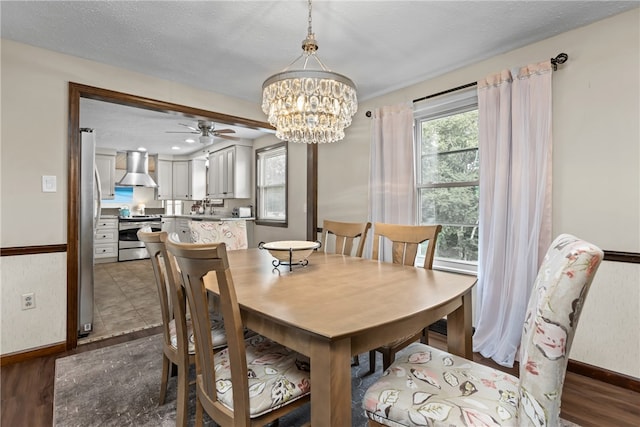 dining space featuring a textured ceiling, dark hardwood / wood-style floors, and ceiling fan with notable chandelier