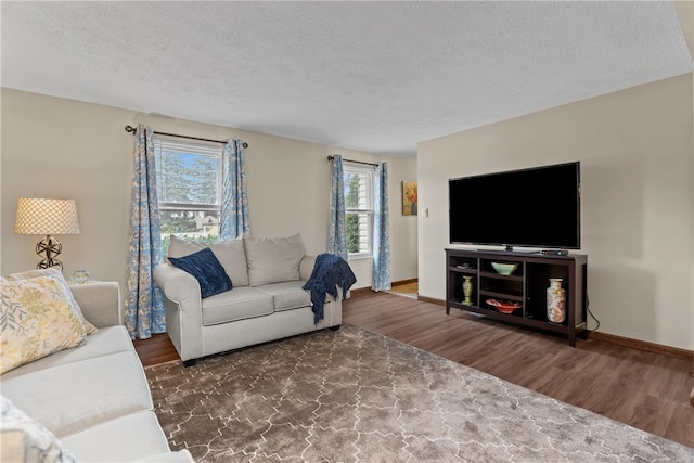 living room with dark wood-type flooring and a textured ceiling