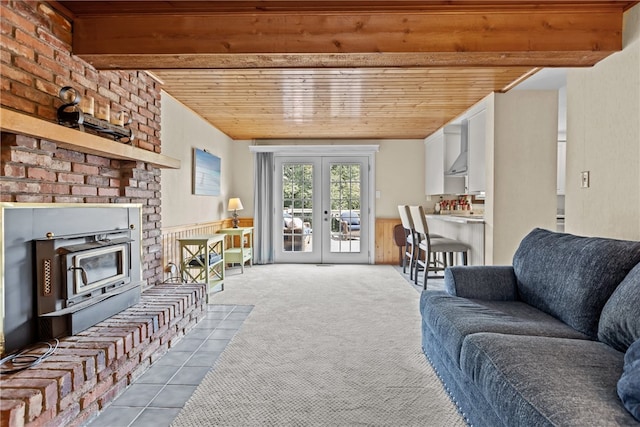 living room featuring brick wall, wooden ceiling, a fireplace, carpet floors, and french doors