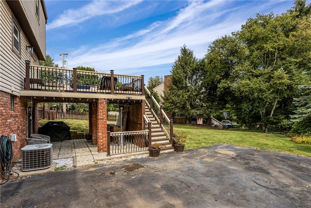 view of patio featuring cooling unit and a deck