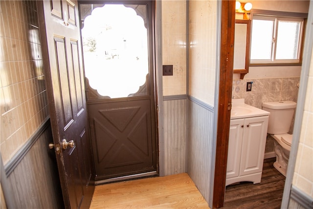 doorway featuring tile walls and hardwood / wood-style floors