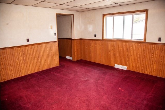 carpeted empty room with a drop ceiling