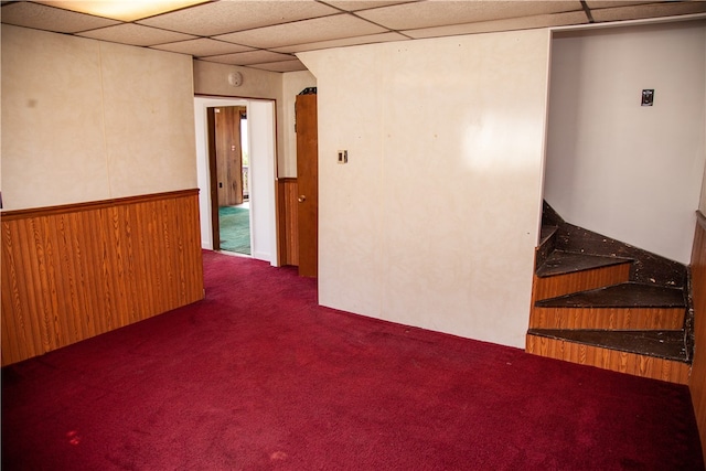 empty room featuring carpet floors and a drop ceiling