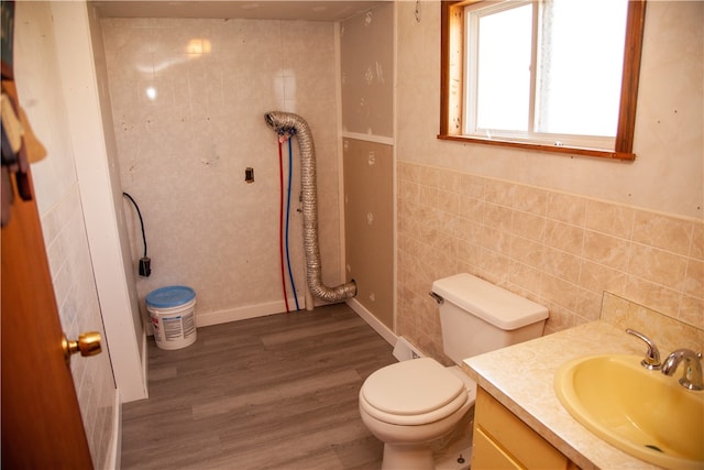 bathroom featuring vanity, tile walls, hardwood / wood-style flooring, and toilet