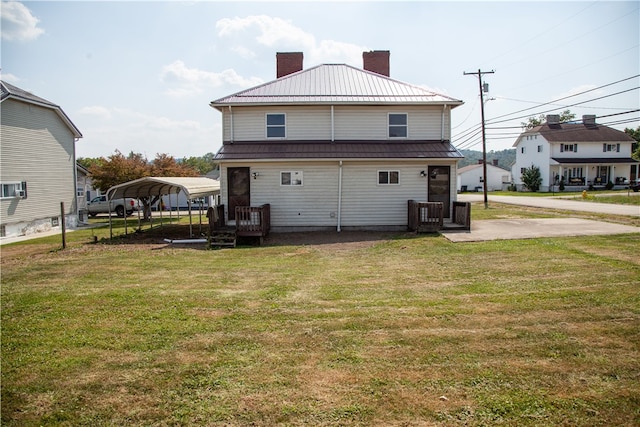 back of house featuring a lawn and a carport