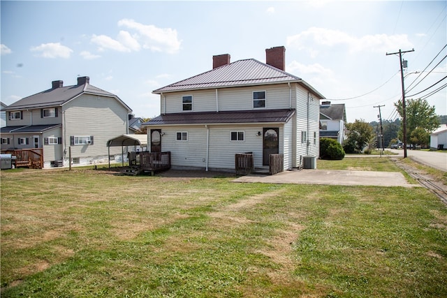 rear view of property featuring a lawn and central AC