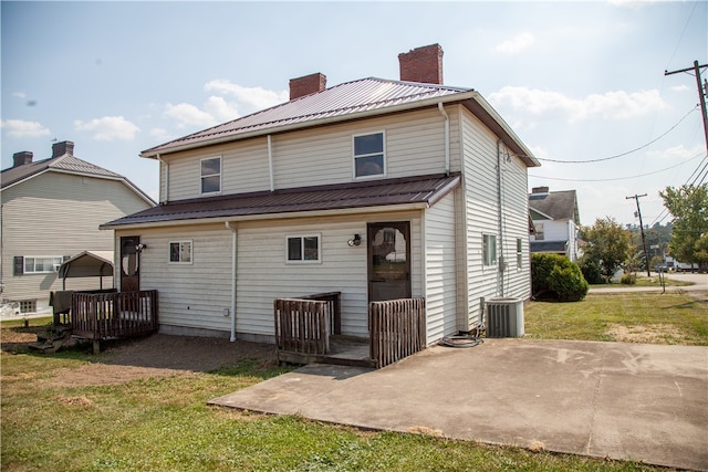 back of house with a patio area and a lawn