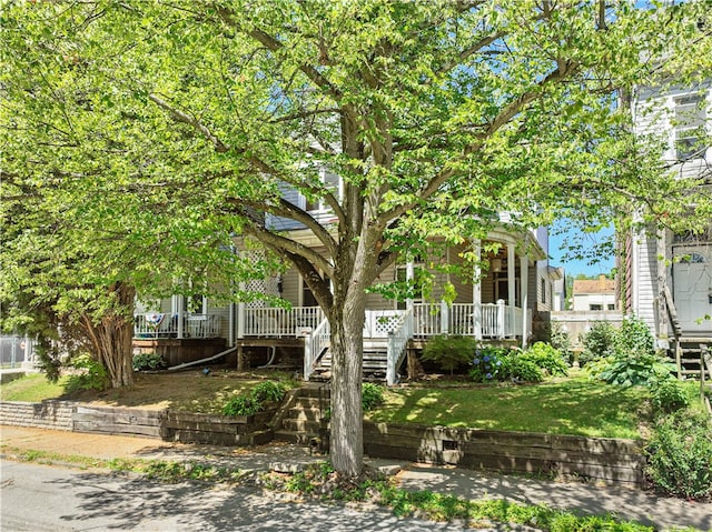 view of front of property featuring a front lawn, stairway, and a porch