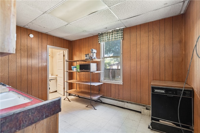 misc room featuring light floors, wood walls, a sink, and a paneled ceiling