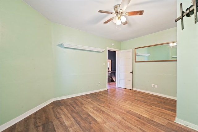 spare room featuring a ceiling fan, baseboards, and wood finished floors