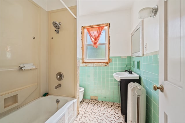 bathroom with shower / washtub combination, tile walls, toilet, radiator heating unit, and vanity